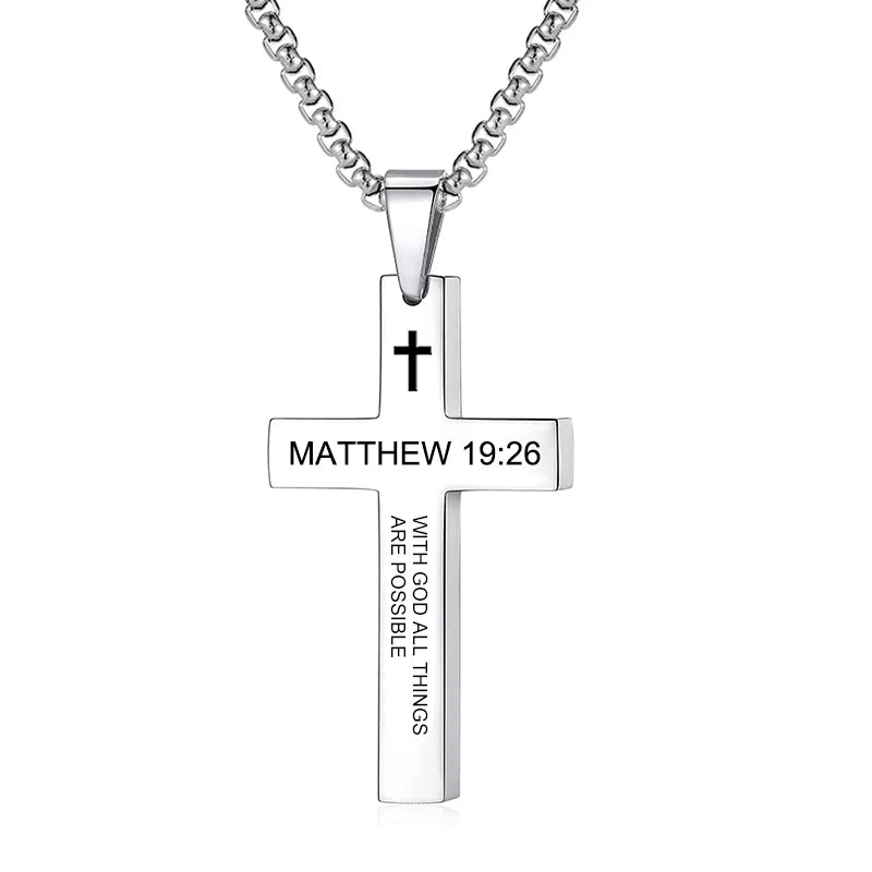 Pendant held between fingers under light to illustrate the actual size, scale, metal sheen, and how the scripture engraving appears up close.