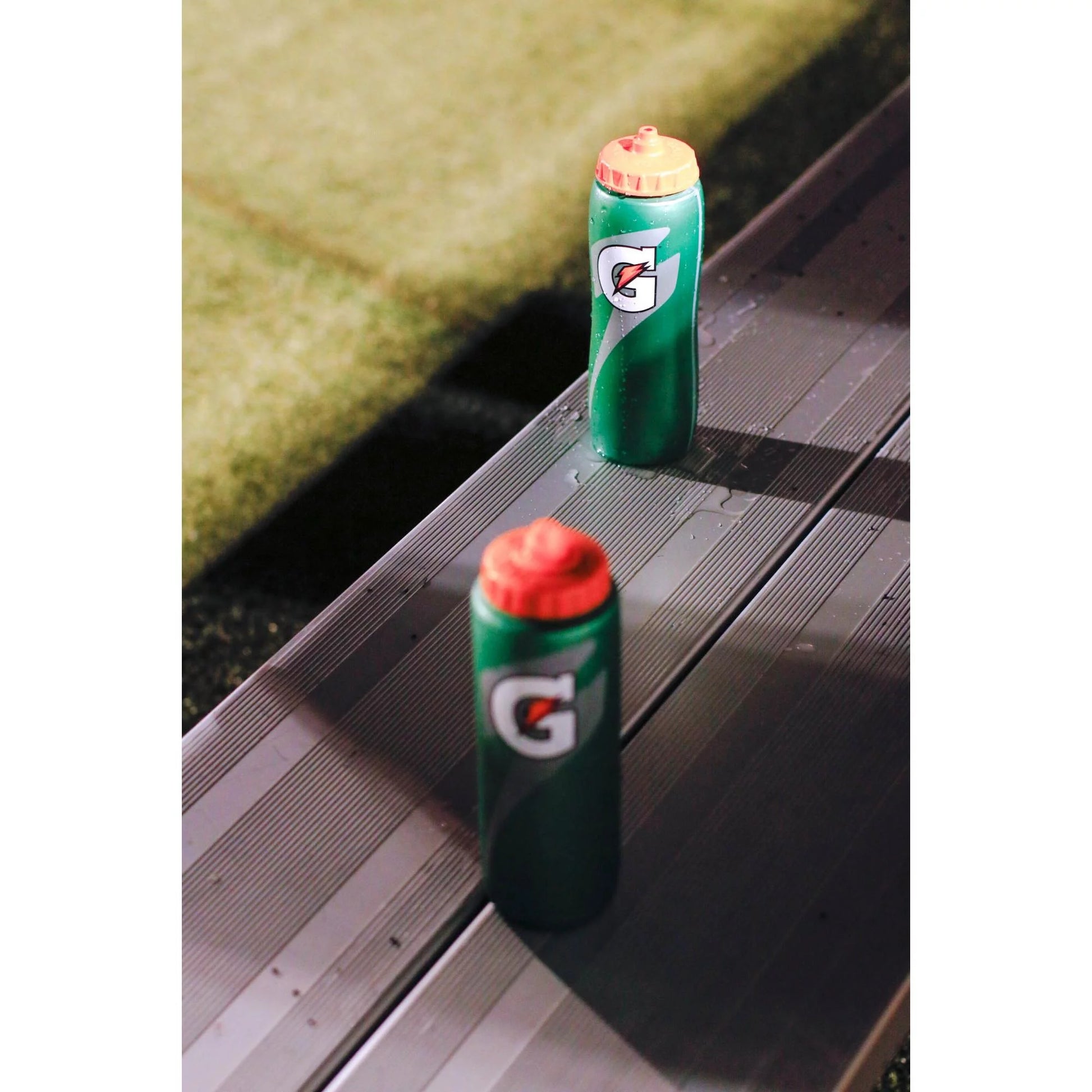 Water bottle with flexible plastic body being squeezed to show how liquid flows out easily via the contour style squeeze mechanism for quick hydration.