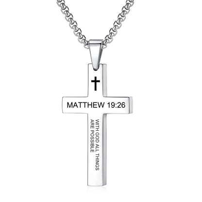 Pendant held between fingers under light to illustrate the actual size, scale, metal sheen, and how the scripture engraving appears up close.